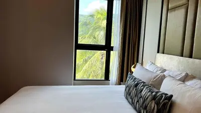 a bedroom with a bed with a large window at Mida Grande Apartment with Rooftop Pool near Surin Beach in Surin Beach