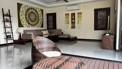 a living room with a couch and a chair at Plunge Tropic Pool Villa near Nai Harn Beach in Rawai Beach