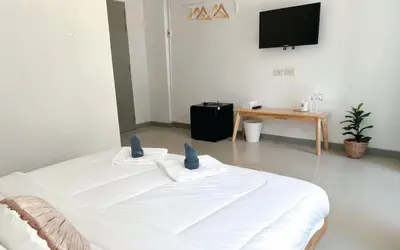 a white bed in a room with a tv at BAOBAB in Patong Beach
