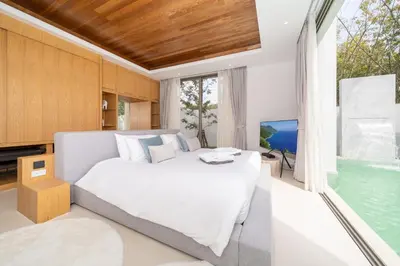 a bedroom with a large bed and a television at The Residence by Andaman Villa in Phuket Town