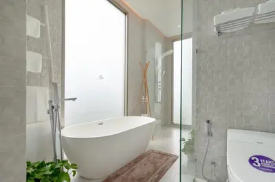 a bathroom with a white tub and a toilet at The Residence by Andaman Villa in Phuket Town