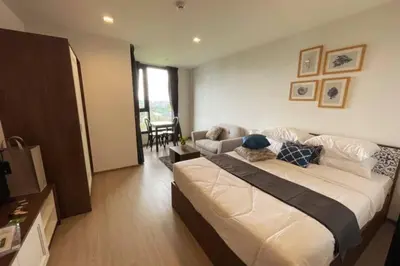 a bedroom with a large bed and a living room at The Base Central - Luxury Resort-Style Comfort in Ban Rangeng