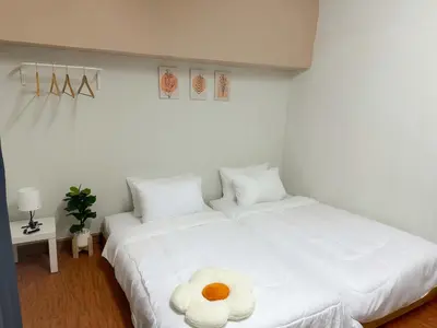 a bedroom with a white bed with a flower on it at MONTANA Hotel & Hostel Phuket in Karon Beach