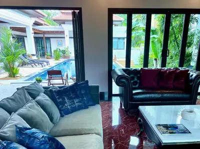 a living room with a couch and a table at Siam Jewel - Private pool villa in Bang Tao in Bang Tao Beach