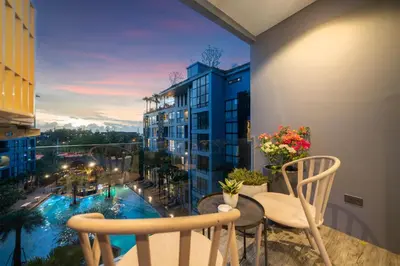 a balcony with a table and chairs and a pool at 5 Stars Facilities Condo Kamala Beach in Kamala Beach