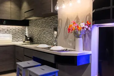 a kitchen with a counter with a vase of flowers at 5 Stars Facilities Condo Kamala Beach in Kamala Beach