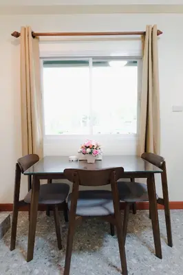 a table and chairs in a room with a window at Kai Mook House in Ban Ket Ho